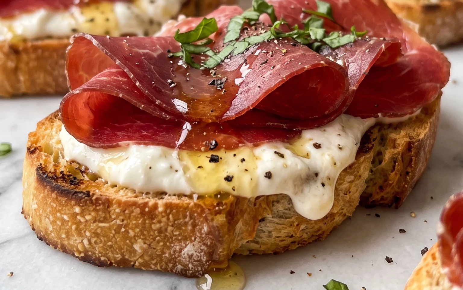 Beef Prosciutto Crostini with Burrata and Lemon Honey Drizzle