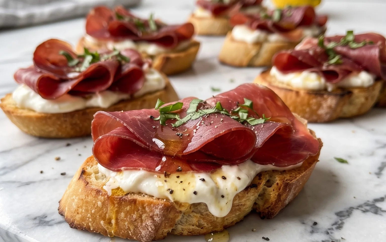 Beef Prosciutto Crostini with Burrata and Lemon Honey Drizzle